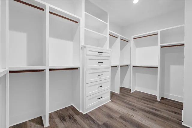 a view of walk in closet with empty racks