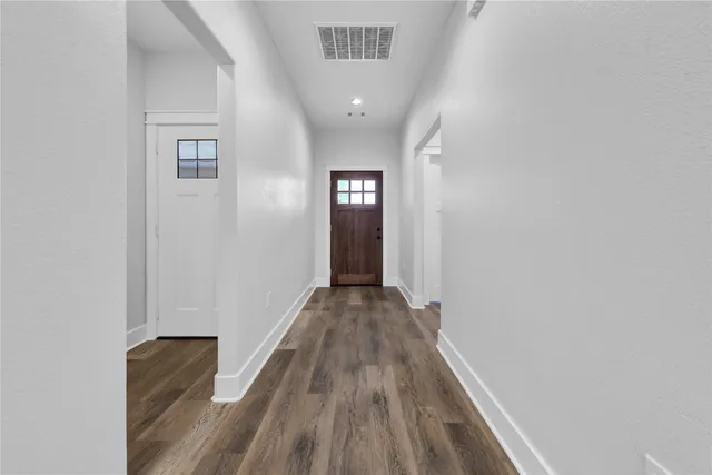 a view of a hallway with wooden floor