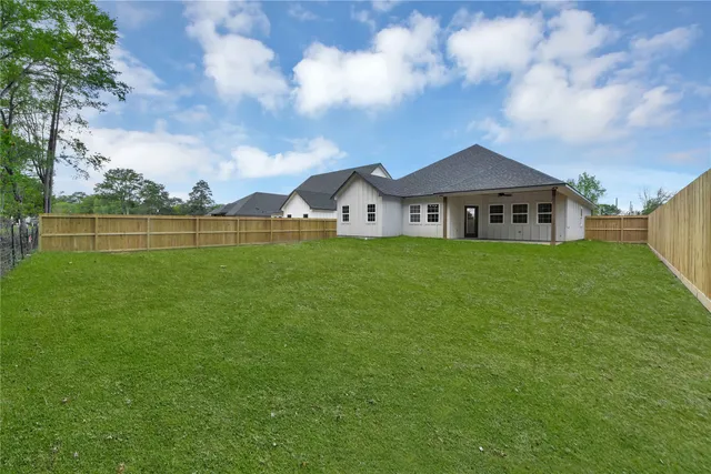 a view of a house with a big yard and large trees