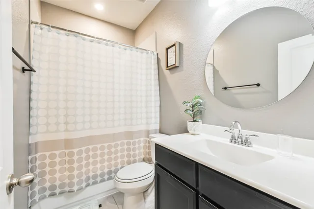 a bathroom with a sink a toilet and shower curtain