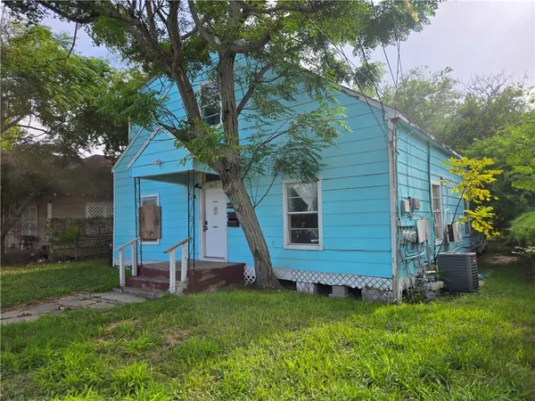 a view of a house with backyard and a tree