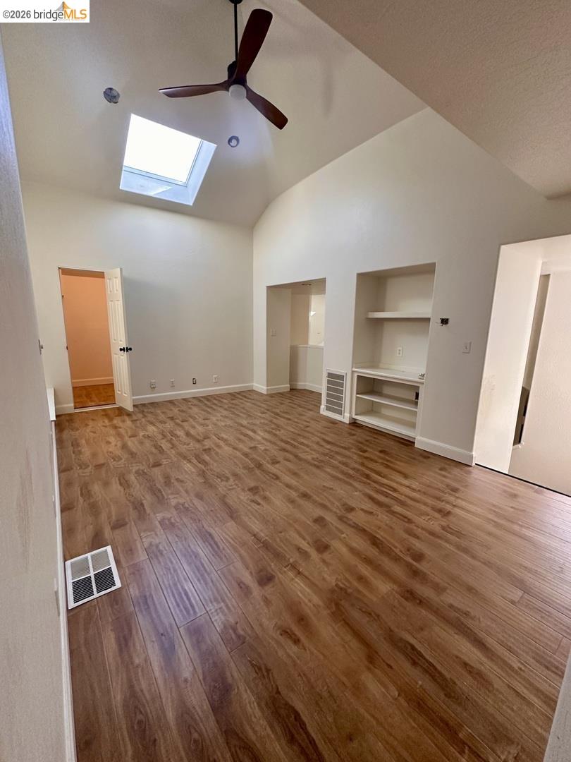 2080 Nelson Road Camino, CA 95709 - Photo 44 of 55 Vaulted ceiling with skylight, wood-finish flooring, built-in shelving, and a ceiling fan
