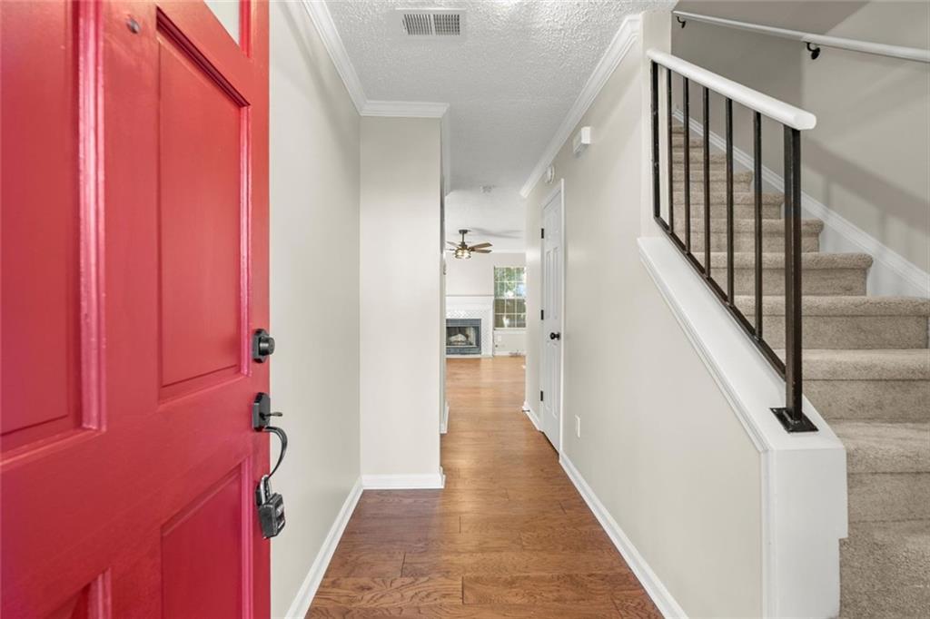a view of a hallway with wooden floor and staircase