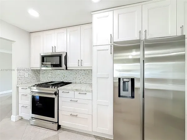 a large kitchen with cabinets and stainless steel appliances