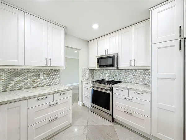 a view of a big room with a chandelier fan and windows
