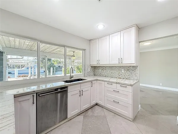 a view of a kitchen with a sink and a refrigerator