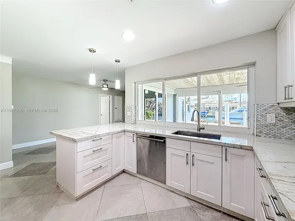a kitchen with granite countertop white cabinets and stainless steel appliances