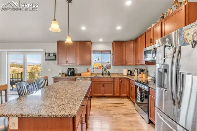 a kitchen with stainless steel appliances granite countertop sink stove refrigerator and cabinets