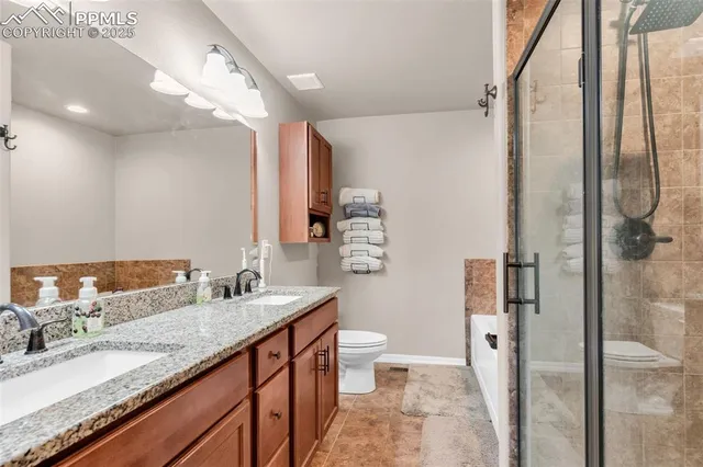 a spacious bathroom with a granite countertop sink mirror and a toilet