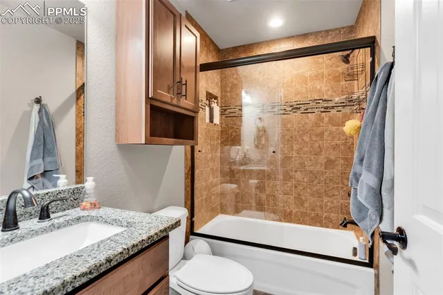 a bathroom with a granite countertop sink toilet and shower