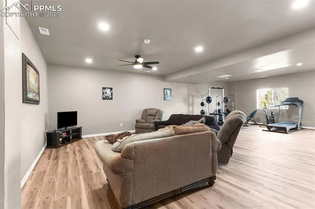 a living room with furniture a flat screen tv and a wooden floor