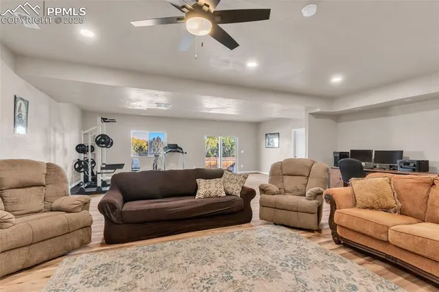 a living room with furniture and a ceiling fan