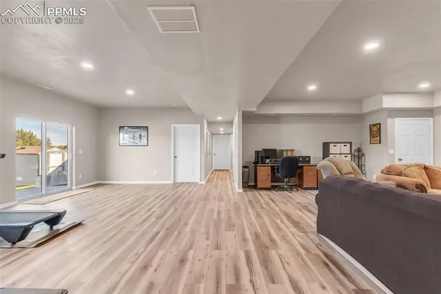 a living room with furniture and a wooden floor