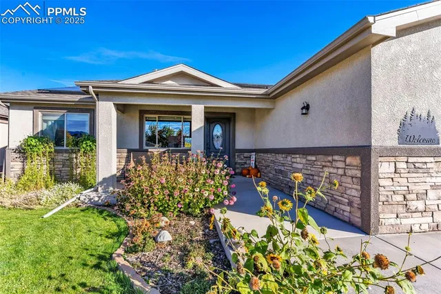 a front view of a house with lots of flowers
