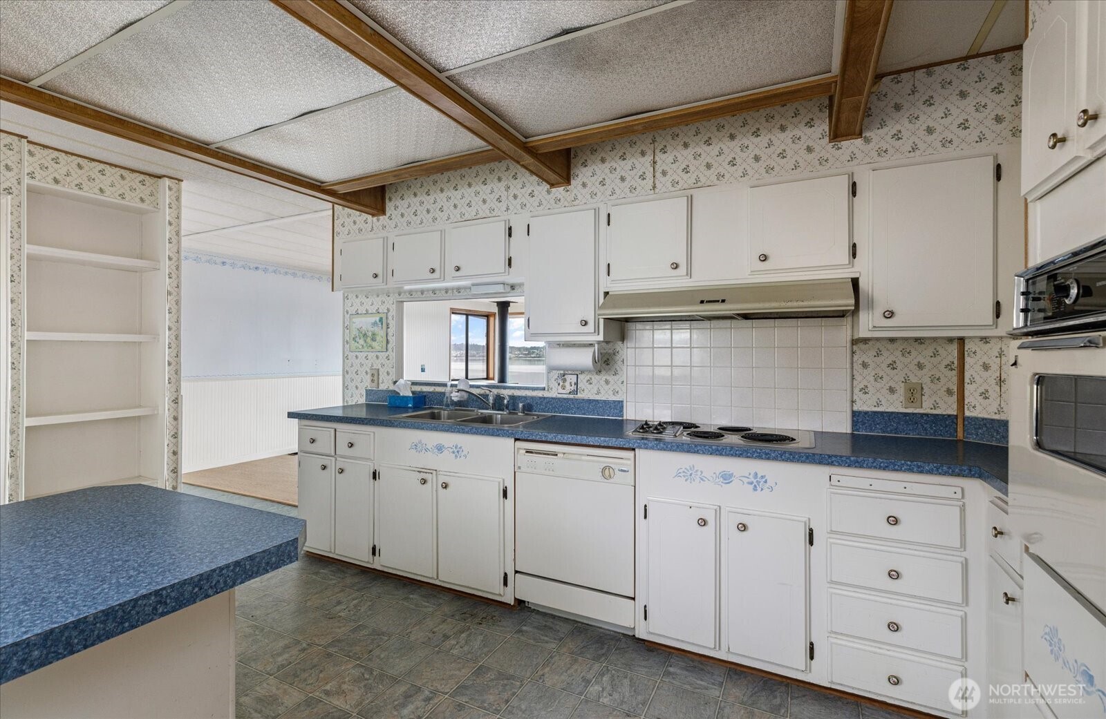 1677 Penn Cove Road Oak Harbor, WA 98277 - Photo 22 of 40 a kitchen with granite countertop white cabinets and white appliances