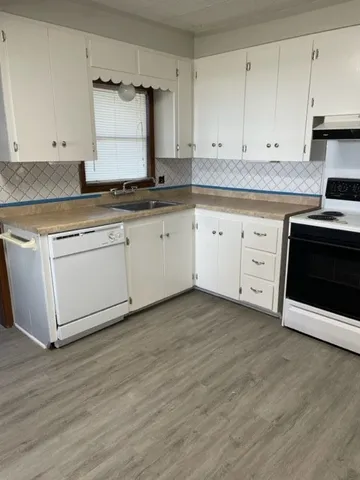 a kitchen with granite countertop white cabinets and white appliances