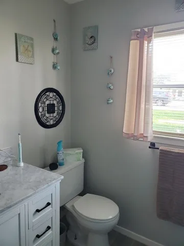 a bathroom with a toilet a sink and a window