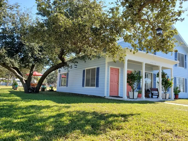 a view of a house with yard and tree s