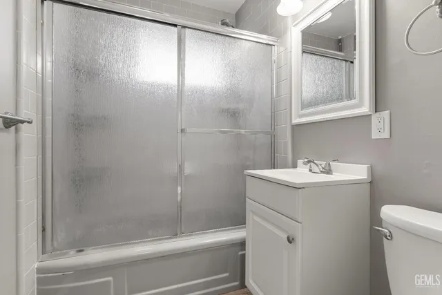 a bathroom with a sink and mirror with toilet