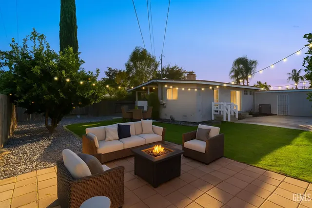 a view of a patio with couches and a table and chairs with wooden fence