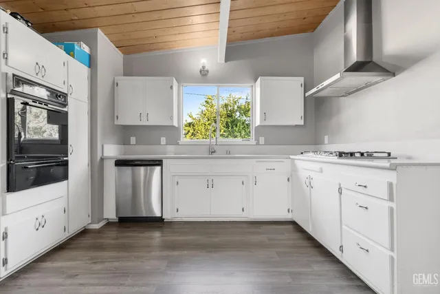 a kitchen with granite countertop white cabinets white stainless steel appliances with a sink and dishwasher