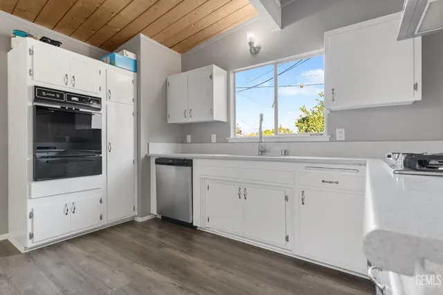 a kitchen with granite countertop white cabinets and white appliances