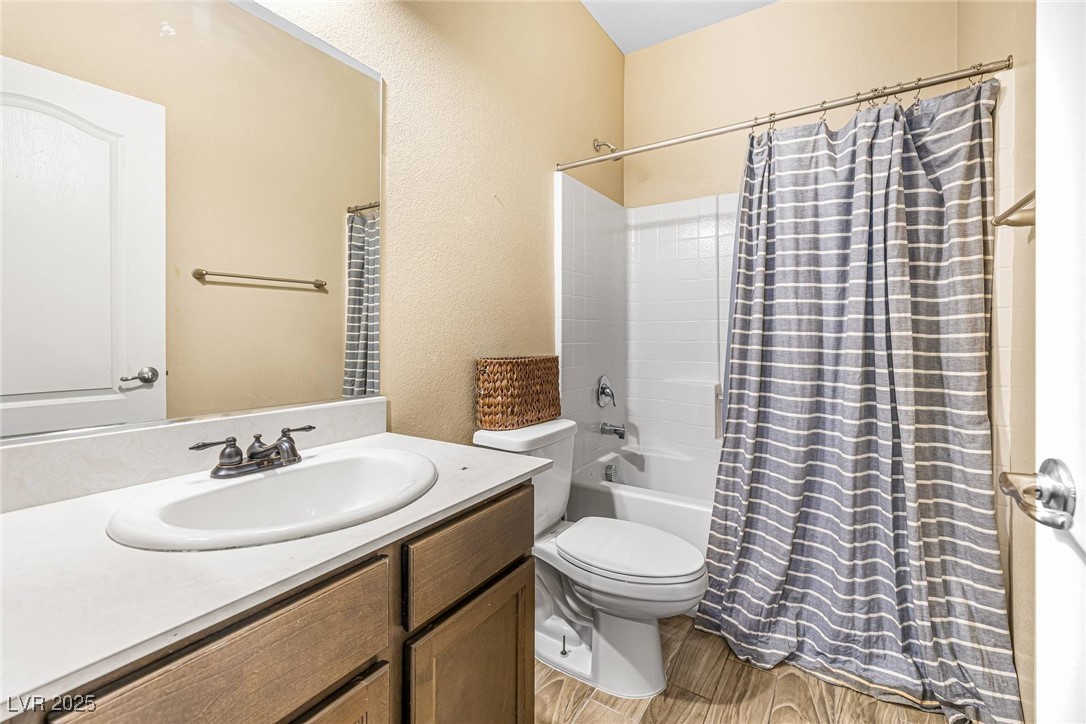10523 Laurel Mountain Lane Las Vegas, NV 89166 - Photo 11 of 36 Downstairs Full bathroom featuring wood finished floors, vanity, a textured wall, and shower / bath combo