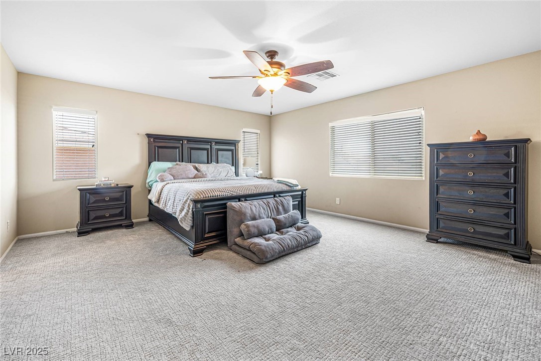 10523 Laurel Mountain Lane Las Vegas, NV 89166 - Photo 13 of 36 Primary Bedroom featuring light colored carpet and a ceiling fan