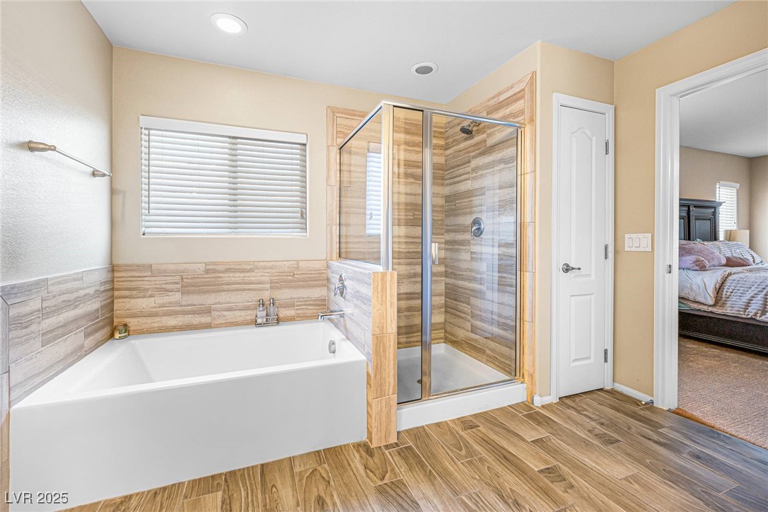 10523 Laurel Mountain Lane Las Vegas, NV 89166 - Photo 16 of 36 Primary Bathroom with a garden tub, wood finished floors, ensuite bathroom, and a shower stall