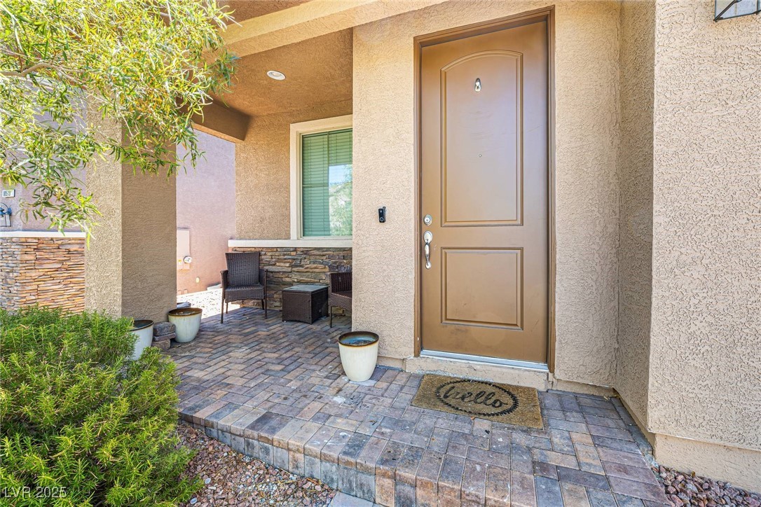 10523 Laurel Mountain Lane Las Vegas, NV 89166 - Photo 31 of 36 Doorway to property featuring stone siding and stucco siding