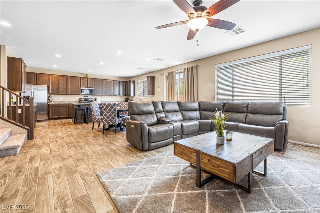 10523 Laurel Mountain Lane Las Vegas, NV 89166 - Photo 8 of 36 Family room with stairway, light wood-style floors, recessed lighting, and ceiling fan