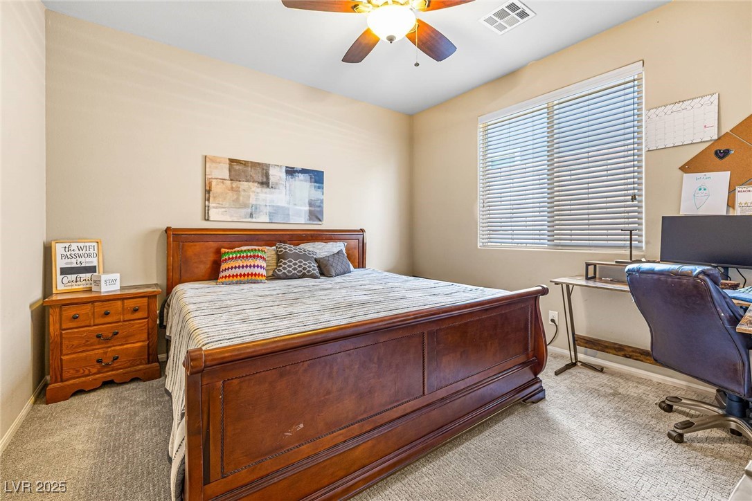 10523 Laurel Mountain Lane Las Vegas, NV 89166 - Photo 10 of 36 Downstairs Bedroom featuring light carpet, ceiling fan, and a desk