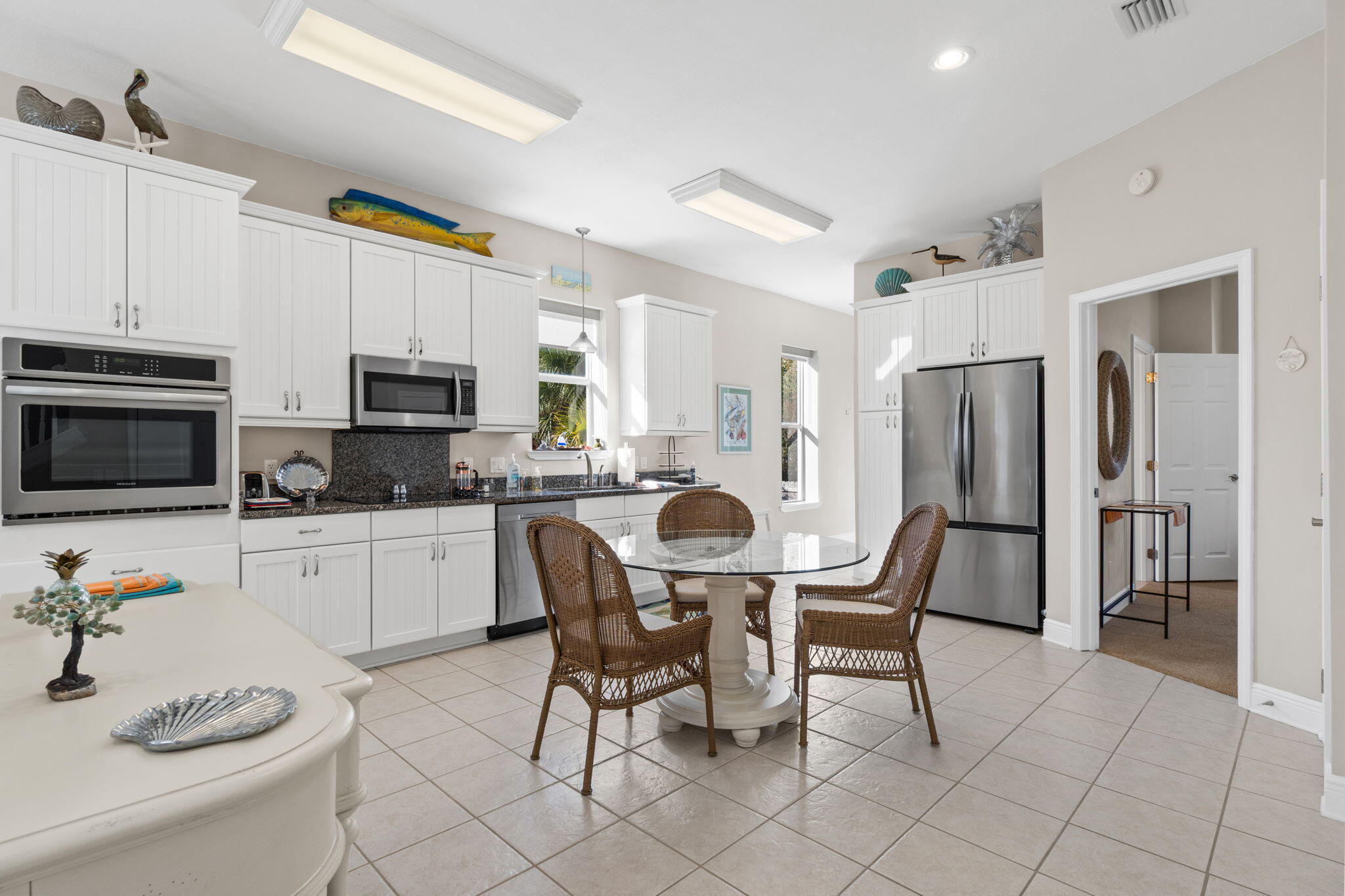 80 Dolphin Street Destin, FL 32541 - Photo 12 of 34 a kitchen with stainless steel appliances a dining table chairs microwave and sink