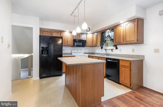a kitchen with stainless steel appliances granite countertop a sink a stove and a refrigerator