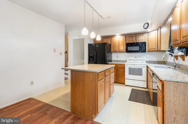 a kitchen with granite countertop a sink cabinets and wooden floor
