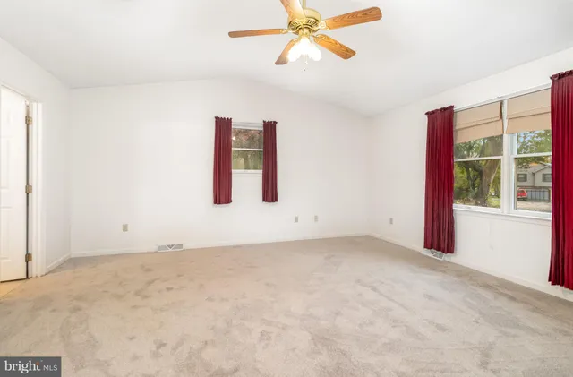 an empty room with closet and fan