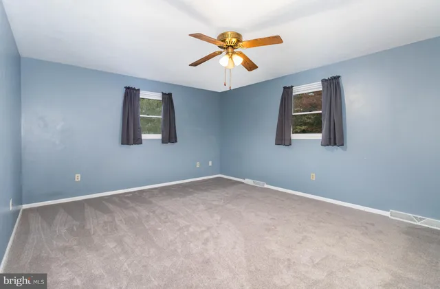 a view of an empty room with a ceiling fan