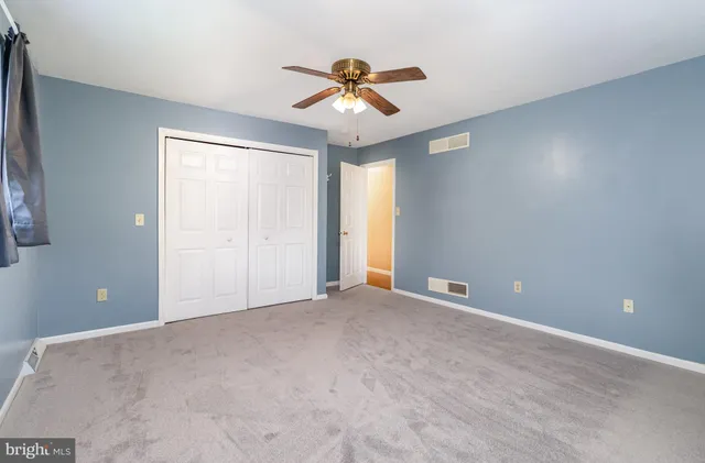 an empty room with a window and a fan