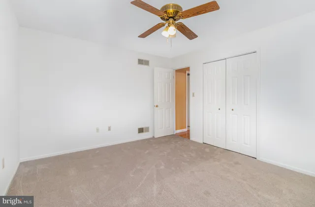 an empty room with a window and a fan