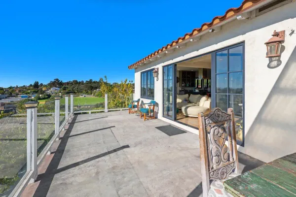 a view of a patio with table and chairs with wooden floor and fence