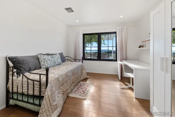 a bedroom with a bed and a large window