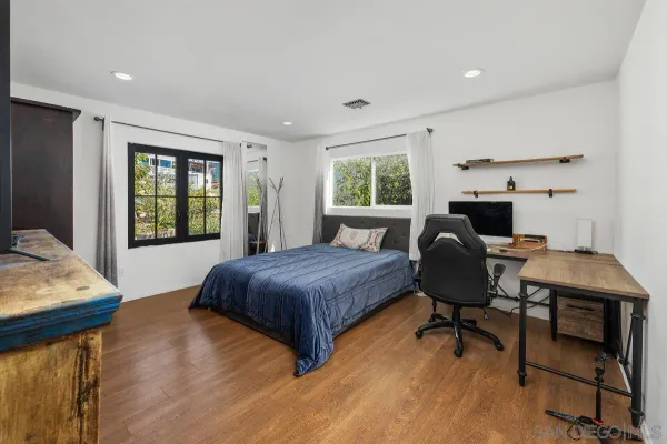 a bathroom with a toilet a sink a mirror and a window