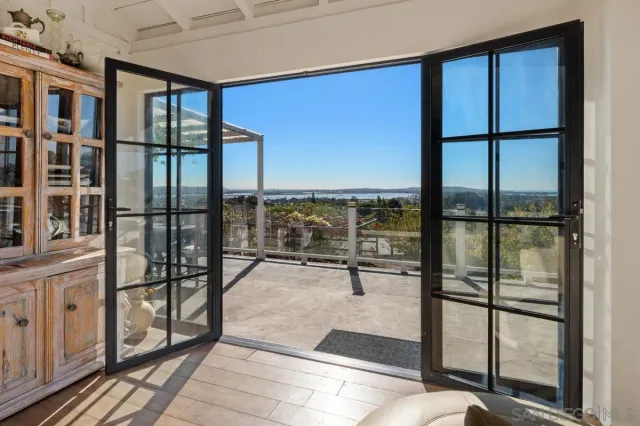 a view of a living room with a floor to ceiling window and wooden floor