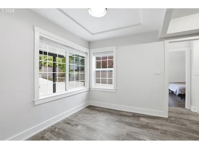 an empty room with wooden floor and a window