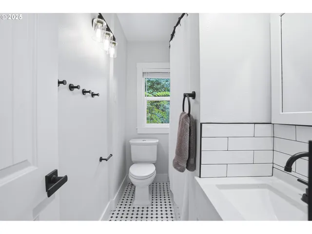 a bathroom with a toilet a sink and a window