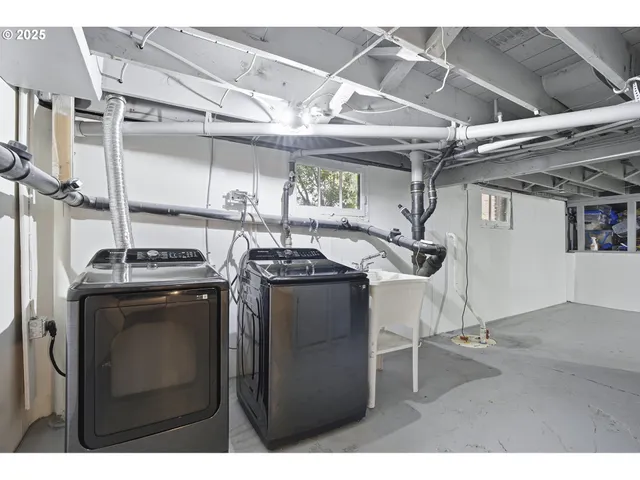 a utility room with dryer washer and stair