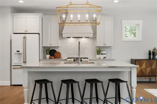 a kitchen with stainless steel appliances a dining table chairs and stove