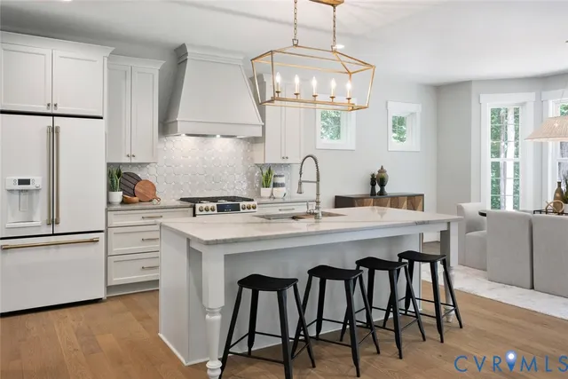 a kitchen with stainless steel appliances a dining table chairs and white cabinets