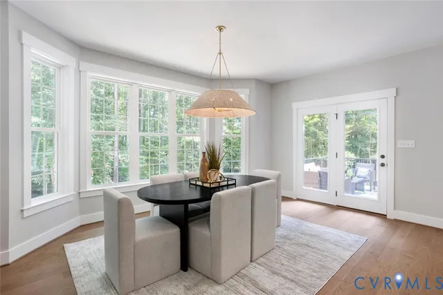 a dining room with wooden floor and a chandelier