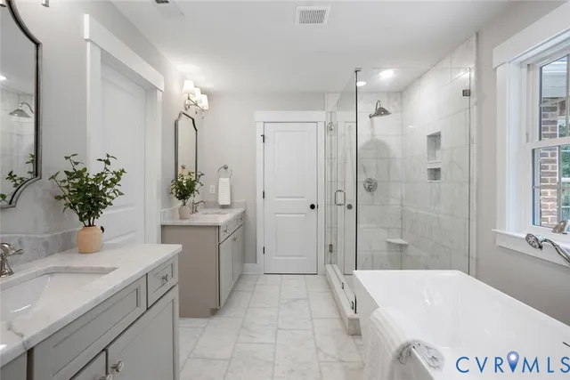 a spacious bathroom with a granite countertop tub sink a mirror a shower and vanity